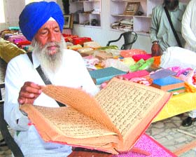 Jathedar Dalip Singh, former vice-president of the SGPC, reads a Persian manuscript at the Mallu Nangal village gurdwara