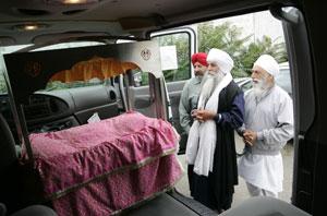 From left to right, Karj Sandhu, Sukhdev Singh and Inder Singh look at the custom-built metal altar upon which the Guru Granth Sahib, the holiest document in the Sikh religion, will rest when being transported to homes for special occasions in the temple's new van. 