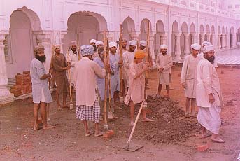 Sikhs doing sewa, repairing the parkarma of the Golden Temple (the marble floor surrounding)